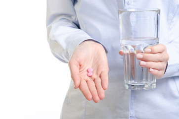 Pink pills and glass of water medicine in woman hand on white background, pharmacy concept