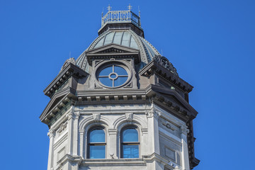 Fototapeta na wymiar Victorian building surmounted by a copper dome (1878). This Magnificent building first housed offices of the Commissioners (edifice des commissaires) of the Port of Montreal. Montreal, Quebec, Canada.