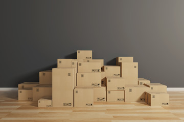 Stack of closed cardboard boxes wrapped with adhesive on the floor. Concept of moving and shipping