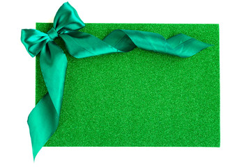 Green bow on glitter green background.