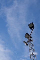 Spotlight pole For illuminating the stadium On a blue sky background