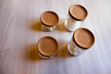Containers of cotton health care supplies over wooden background