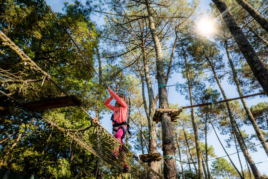 belle jeune fille dans un parc d'accrobranche