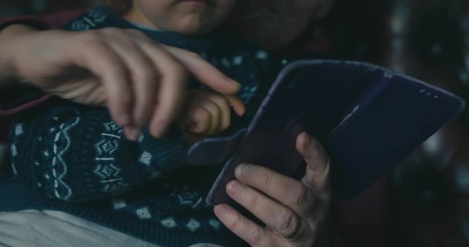 Little toddler using smartphone with his grandmother