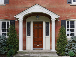 brick house, wooden front door with portico cover