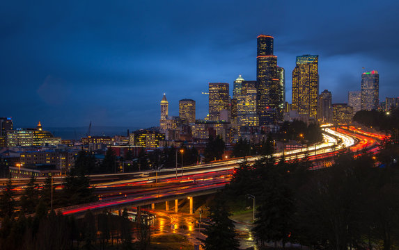 Seattle skyline at hour traffic with light trails.