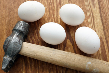 Risk assessment concept. Hummer and eggs on a desk.