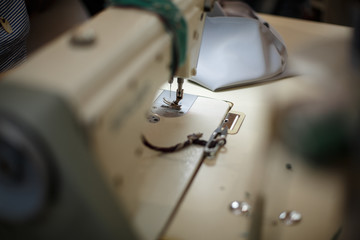 Fototapeta na wymiar Close-up of a sewing machine with light on. workplace tailor. sewing industry