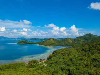 Fototapeta na wymiar Aerial view of tropical island Bulalacao. Beautiful tropical island with white sandy beach, palm trees and green hills. Travel tropical concept. Palawan, Philippines