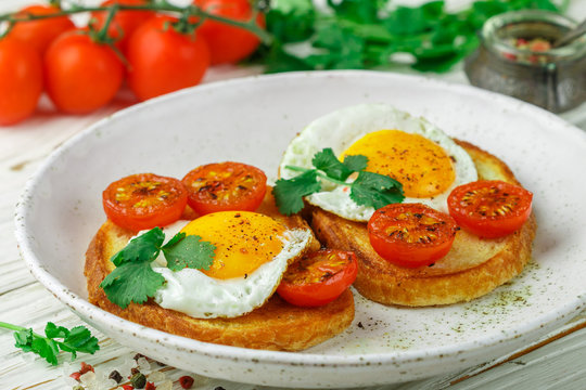 Bruschetta with fried egg, tomatoes and herbs. Delicious breakfast. Selective focus