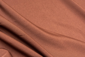 Texture of dark brown fabric closeup. Low key photo. Plexus threads. Clothing industry. Abstract background. Textile waves.