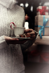 cup in hand and stack gifts