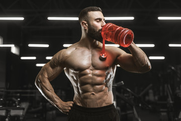 Fototapeta na wymiar Handsome strong athletic muscles men drink water and sport nutrition workout bodybuilding concept background