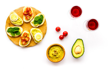 Healthy snacks. Set of toasts with vegetables like avocado, guacamole, rocket, cherry tomatoes on white background top view