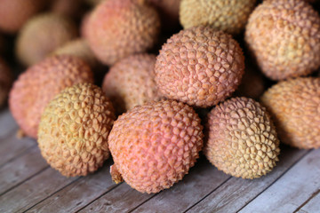 Lychees on a wooden table. Fresh harvest of exotic fruit lychee