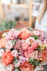 beautiful fresh cut bouquet of mixed flowers in woman hand. the work of the florist at a flower shop. Delicate Pastel tones color