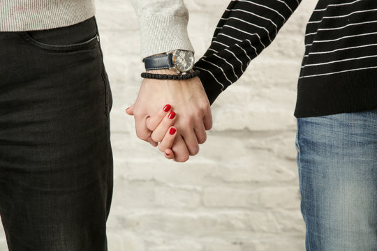 Young couple holding hands, close up image
 