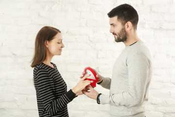 Portrait of a young couple.Young man surprising his girlfriend with a gift   