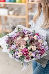 beautiful fresh cut bouquet of mixed flowers in woman hand. the work of the florist at a flower shop. Delicate Pastel tones color
