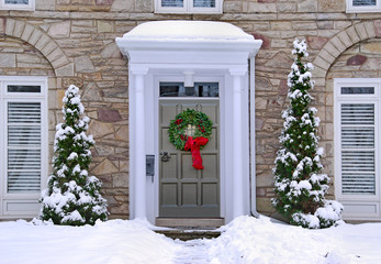 front door with colorful wreath in winter scene