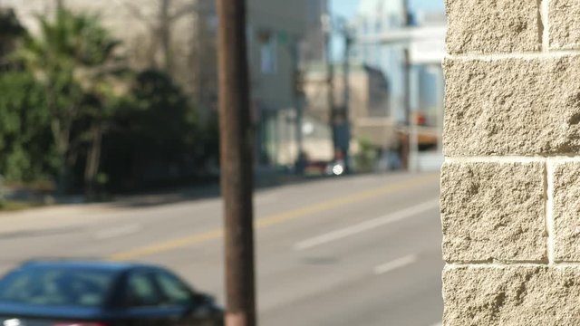 Street scene backplate with foreground in focus and background soft for keying in talent includes traffic and masonry wall.