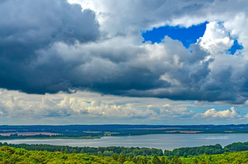 Fototapeta na wymiar View over forests on the island of Rügen, Germany, towards dramatic clouds that announce a storm.