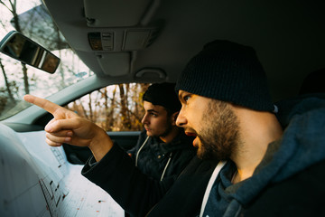 Two armed bandits sitting in a car planning their next robbery, while counting on a stopwatch the...