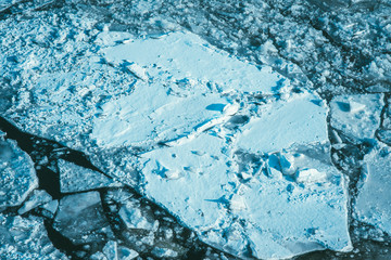 Aerial view of frozen lake. Cracked Ice from drone view. Background texture concept