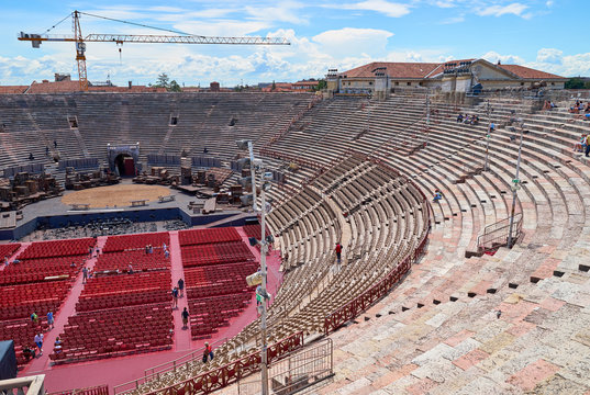 Inside of Arena of Verona in Italy / 
Red seats under blue sky in the theater