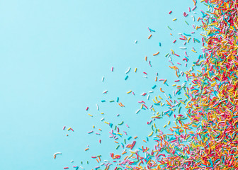 Birthday and party concept background with confetti, decoration and lollipop on blue