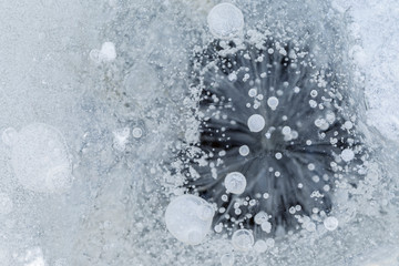 Close-up of frozen air bubbles in ice in the winter, viewed from above. Abstract full frame background. Copy space.