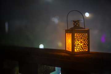 Retro style lantern at night. Beautiful colorful illuminated lamp at the balcony in the garden. Selective focus - Powered by Adobe