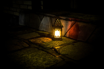 Fototapeta na wymiar Beautiful colorful illuminated lamp in the garden in misty night. Retro style lantern at night outdoor.
