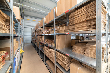 Warehouse shelves with cardboard boxes and packs in paper packaging