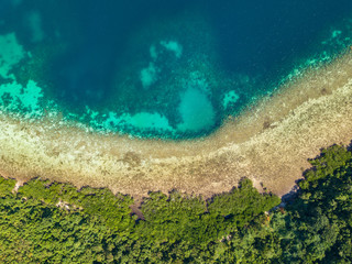 Obraz premium Aerial top view of tropical island Bulalacao. Beautiful tropical island with white sandy beach, palm trees and green hills. Travel tropical concept. Palawan, Philippines