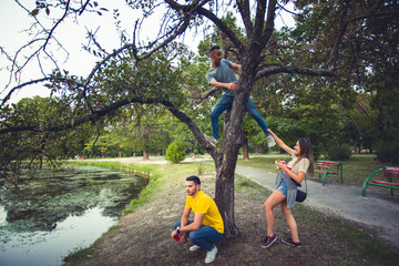 Freinds climbing trees in the park