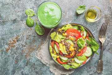 Fresh healthy salad with quinoa, red tomatoes, sweet pepper, cucumber, corn and avocado on stone background, top view. Healthy food. Superfood meal.