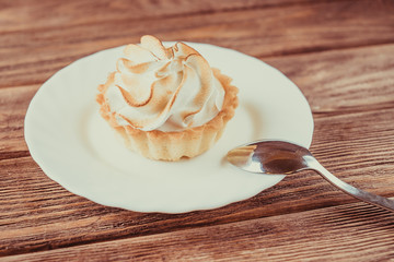 Cupcake with whipped cream on a white saucer.