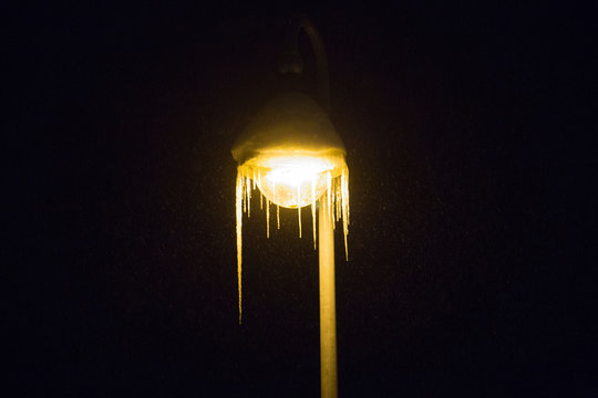 street lamp at night covert with snow and ice