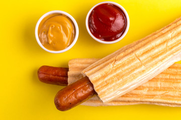 Two grilled french hot dogs with mustard and ketchup