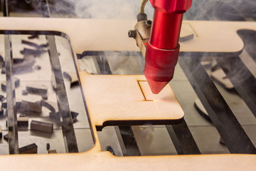 Laser engraver working and engraving wooden board