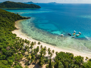 Aerial view of tropical  beach of island Bulalacao. Beautiful tropical island with white sandy beach, palm trees and green hills. Travel tropical concept. Palawan, Philippines