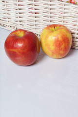 Apples on the table. Next to white wicker baskets.