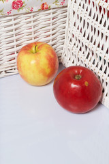 Apples on the table. Next to white wicker baskets.