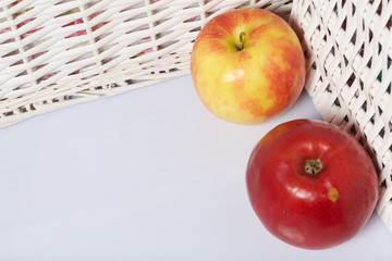 Apples on the table. Next to white wicker baskets.