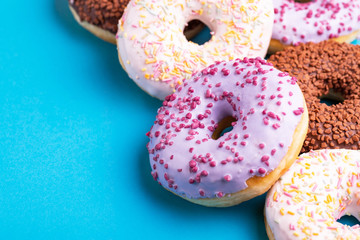 Assorted delicious donuts on bright blue background