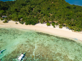 Aerial view of tropical  beach of island Bulalacao. Beautiful tropical island with white sandy beach, palm trees and green hills. Travel tropical concept. Palawan, Philippines