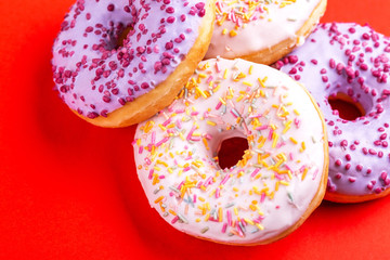 Delicious berry and vanilla donuts on bright red background