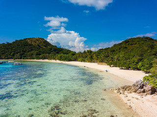 Aerial view of tropical  beach of island Bulalacao. Beautiful tropical island with white sandy beach, palm trees and green hills. Travel tropical concept. Palawan, Philippines