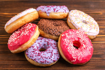 Assorted delicious donuts on rustic wooden background